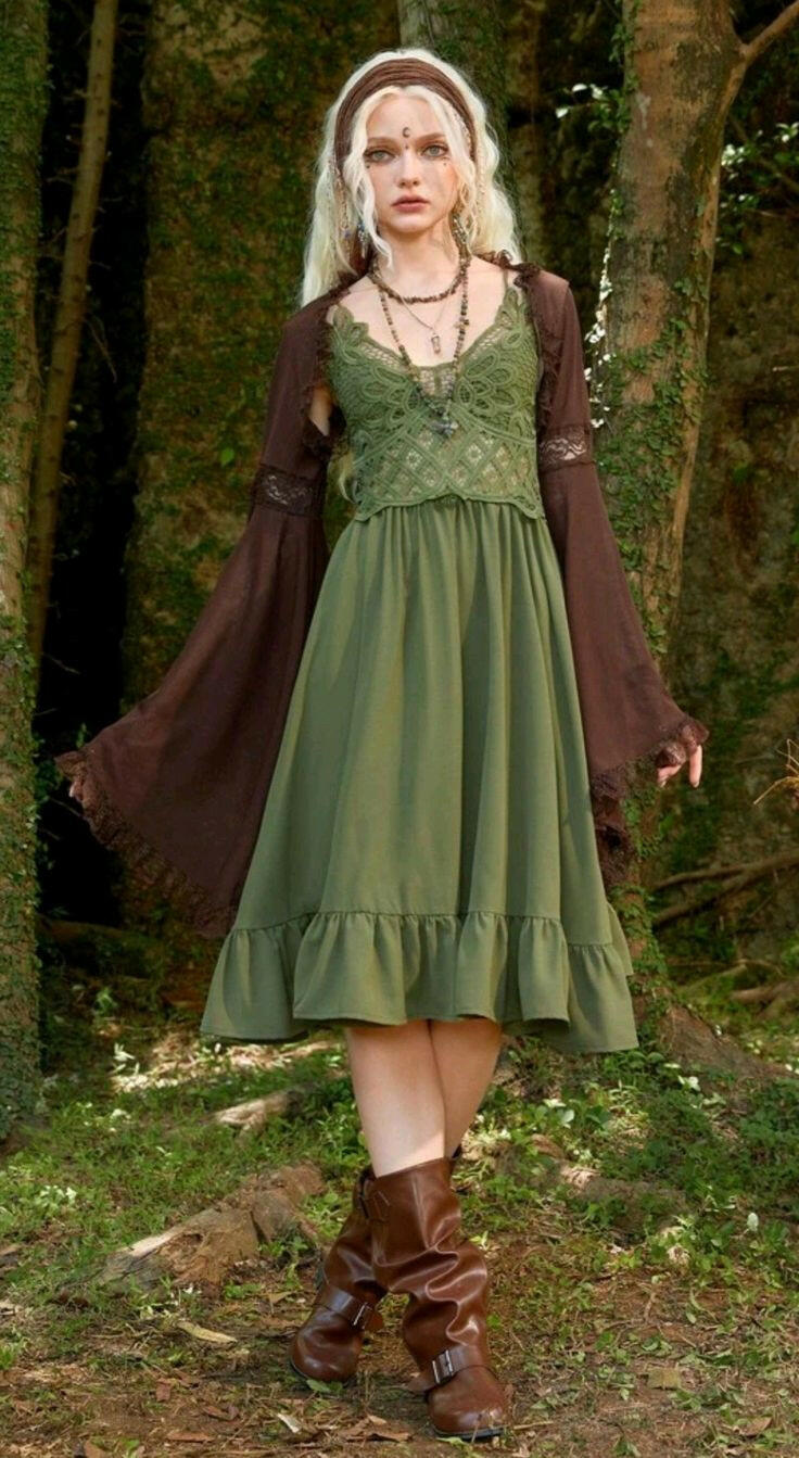 Woman in a green dress with brown sleeves standing in a forest