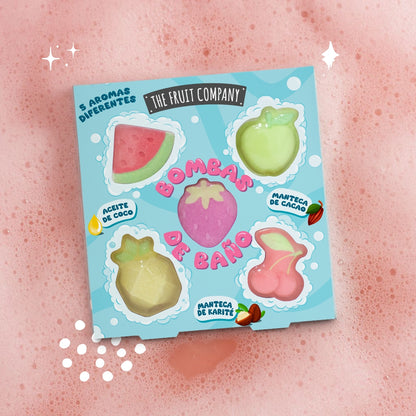 Packaging of bath bombs with fruit designs on a pink background