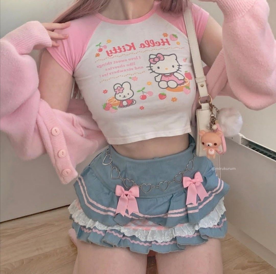 Person wearing a Hello Kitty-themed outfit with a pink sweater and skirt.