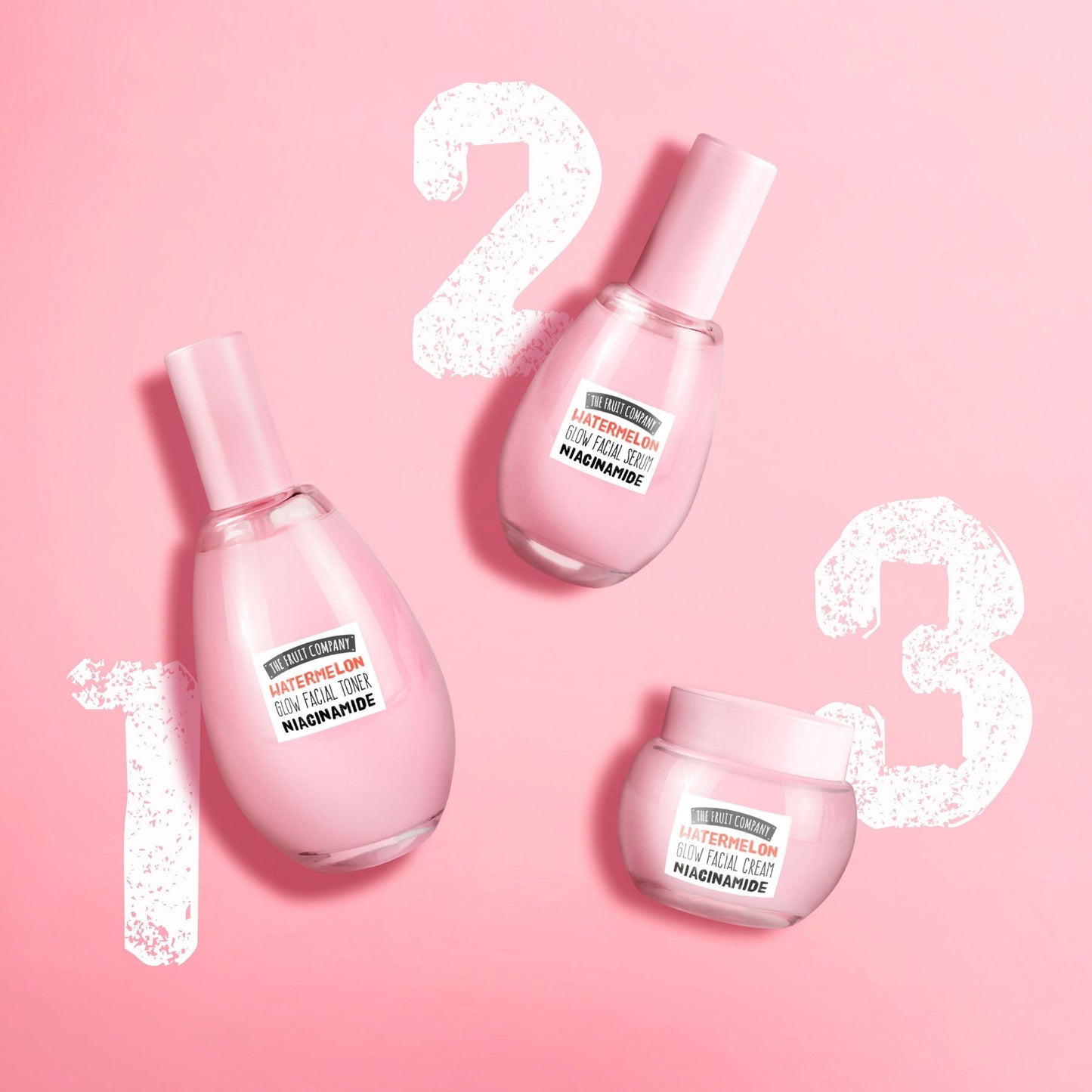 Three pink skincare products with labels on a pink background