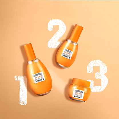 Three orange skincare products with a beige background