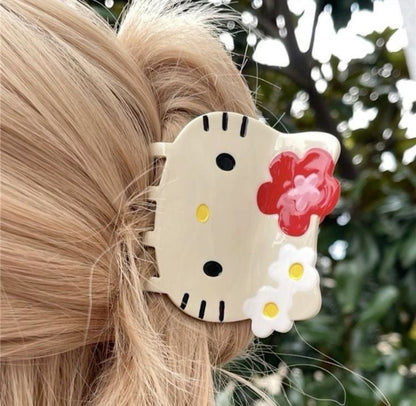 Hair clip with a cartoon design featuring flowers in a blurred outdoor setting