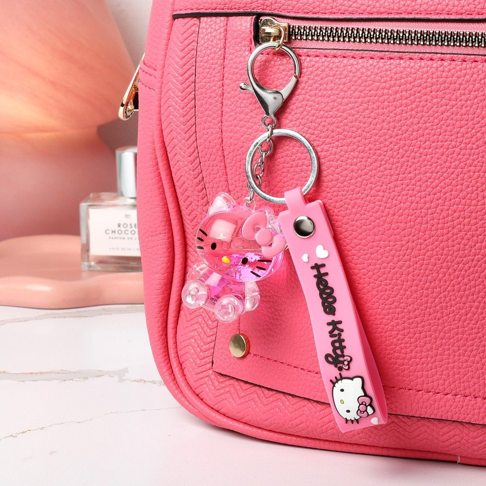 Pink Hello Kitty keychain attached to a pink bag with a blurred background