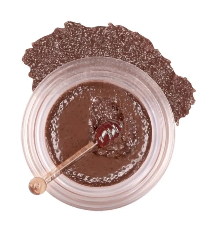 Jar of brown cream with a spoon inside on a white background