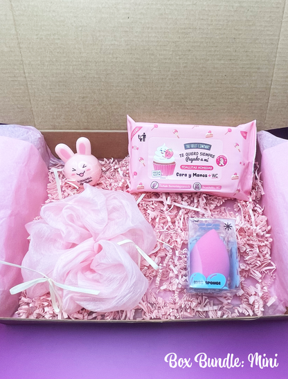 A variety of pink-themed items including makeup, beauty care products, and fashion accessories arranged neatly inside a pink box with a 'Box Bundle: mini' label.