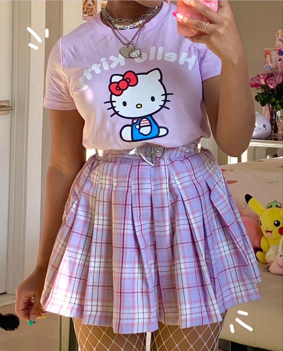 Person wearing a purple t-shirt with a cartoon character and a plaid skirt.