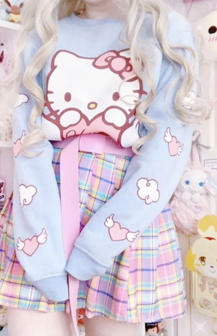 Person wearing a pastel-colored outfit with Hello Kitty design, surrounded by plush toys.